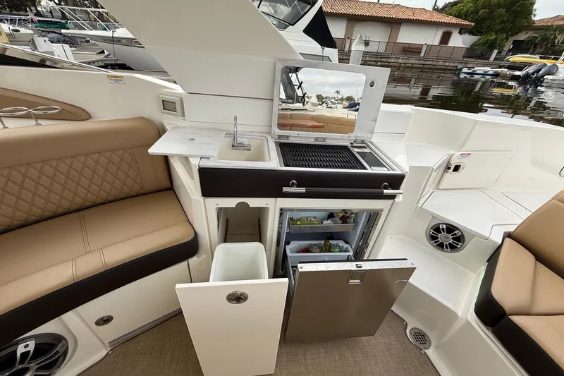 Slide: The Image of 2023 Sea Ray SLX 350 boat interior with kitchenette, grill, and seating area. - 22