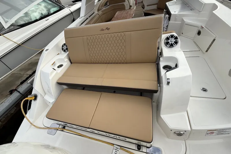 Slide: The Image of 2023 Sea Ray SLX 350 boat interior with tan seating and built-in speakers. - 14