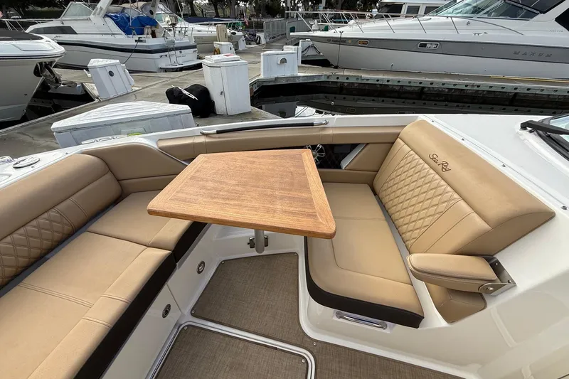 Slide: The Image of Luxurious seating area on 2023 Sea Ray SLX 350 boat with wooden table. - 34