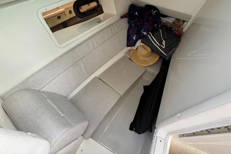 Slide: The Image of 2023 Sea Ray SLX 350 cabin interior with gray seating and personal items. - 32