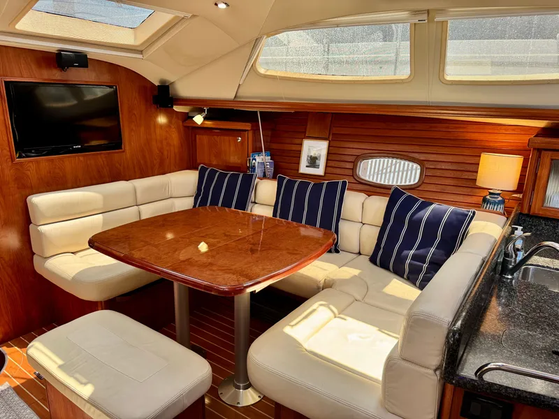 Slide: The Image of The interior of a 2009 Hunter 50 Center Cockpit features a cozy seating area with a wooden table. - 39