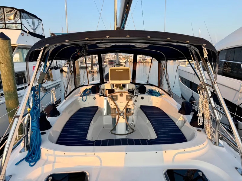 Slide: The Image of The image shows the cockpit of a 2009 Hunter 50 Center Cockpit yacht. It features blue cushions and a steering wheel. - 17