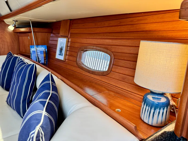 Slide: The Image of Interior of a 2009 Hunter 50 Center Cockpit with wooden walls, blue cushions, and a lamp. - 40