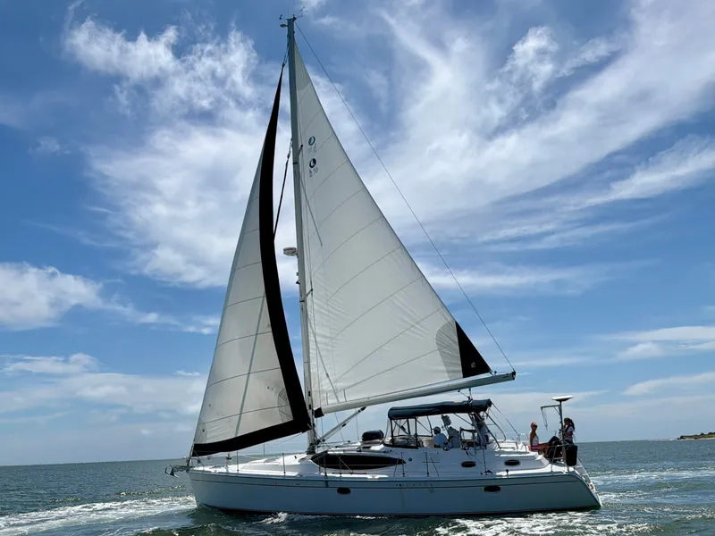 Slide: The Image of A 2009 Hunter 50 Center Cockpit yacht sails on open water under a blue sky. - 5