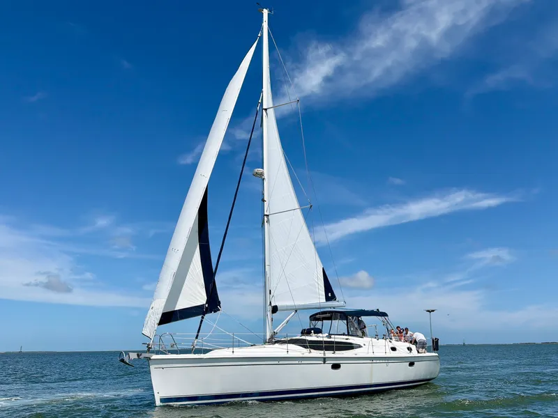 Slide: The Image of A 2009 Hunter 50 Center Cockpit yacht sailing on calm waters under a blue sky. - 1