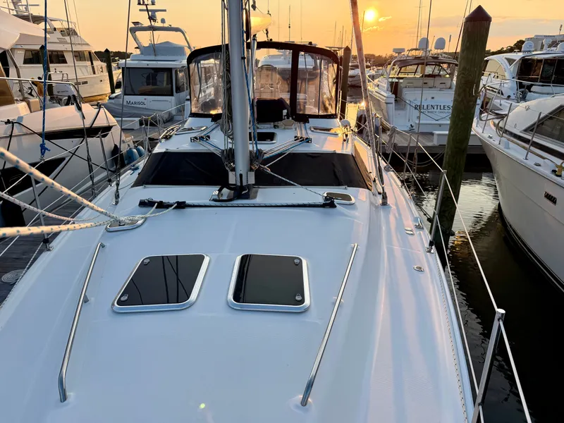 Slide: The Image of A 2009 Hunter 50 Center Cockpit docked in a marina. The sun sets in the background. - 25