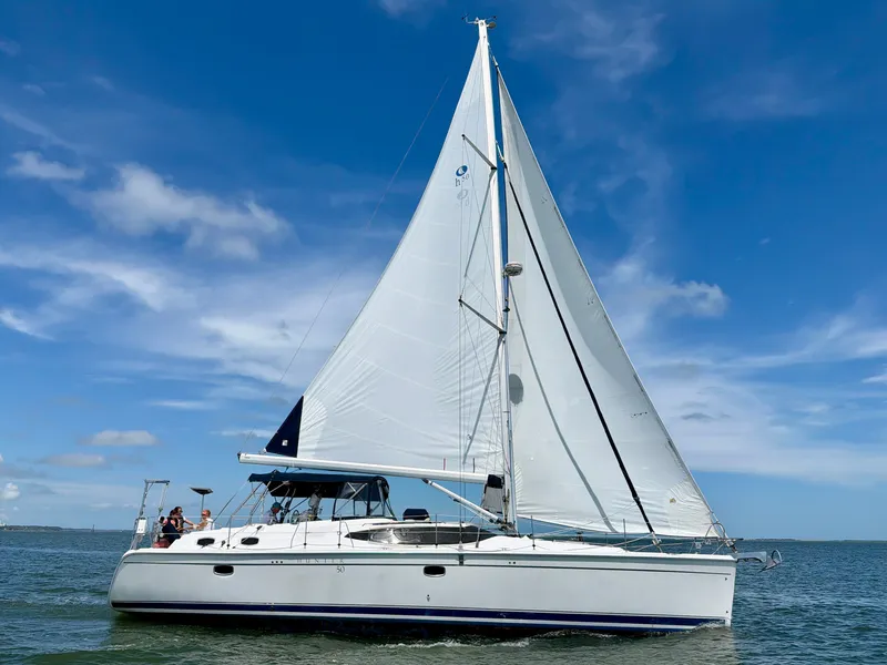 Slide: The Image of A 2009 Hunter 50 Center Cockpit yacht sails on calm waters under a blue sky. - 2