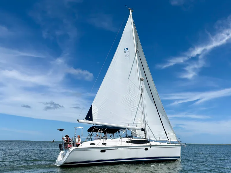 Slide: The Image of 2009 Hunter 50 Center Cockpit sailboat on calm water under a blue sky. - 3