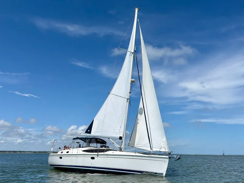 The Image of A white sailing yacht with two sails glides on calm water under a blue sky. - 0