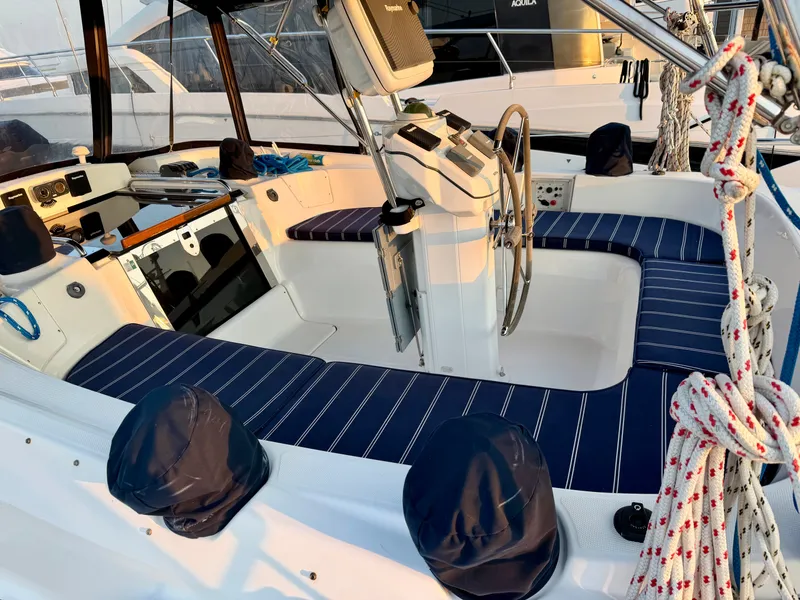 Slide: The Image of The cockpit of a 2009 Hunter 50 Center Cockpit with blue seating cushions and a steering wheel. - 20
