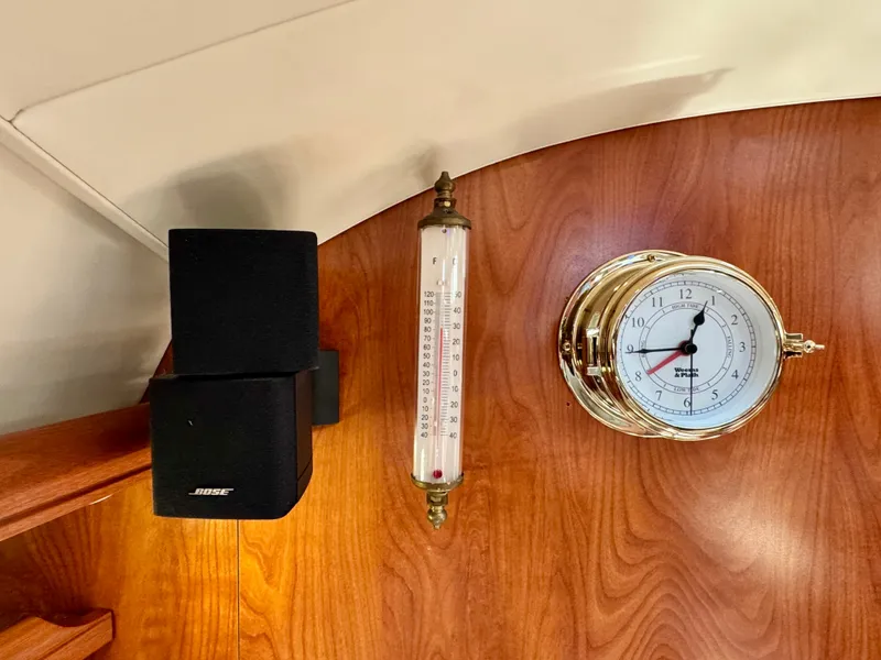 Slide: The Image of An elegant interior featuring a wall clock, thermometer, and speaker. - 49
