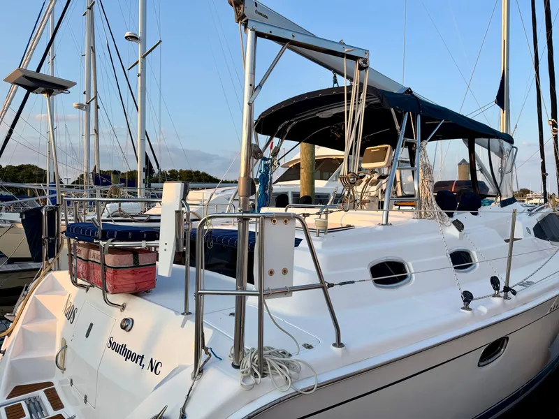 Slide: The Image of A 2009 Hunter 50 Center Cockpit yacht docked in a marina, featuring a spacious deck and sunshade. - 12