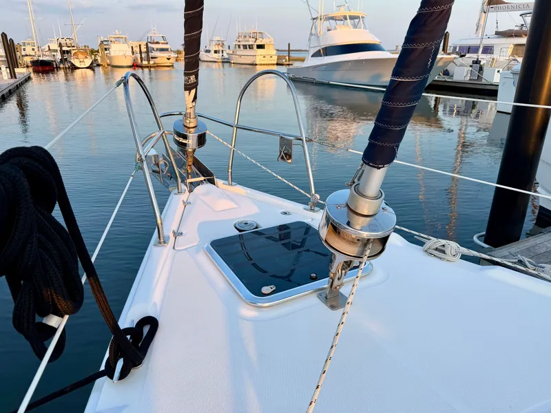 Slide: The Image of The deck of a 2009 Hunter 50 Center Cockpit in a marina, surrounded by other boats. - 27