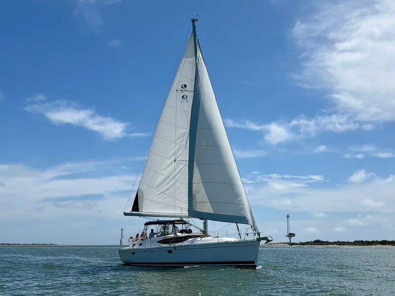 Slide: The Image of A 2009 Hunter 50 Center Cockpit yacht sails on calm waters under a blue sky. - 9
