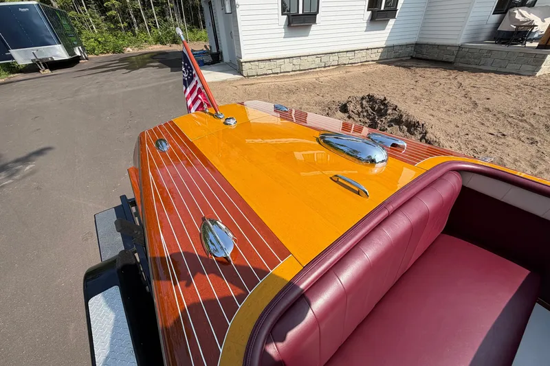 Slide: The Image of 1953 Chris Craft Riviera boat with polished wood finish and American flag. - 27