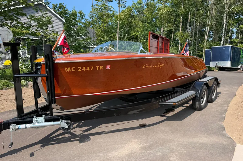 Slide: The Image of 1953 Chris Craft Riviera boat on trailer, showcasing classic wooden design and vibrant finish. - 31