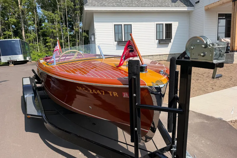Slide: The Image of 1953 Chris Craft Riviera boat on trailer, showcasing classic wooden design and vibrant finish. - 8