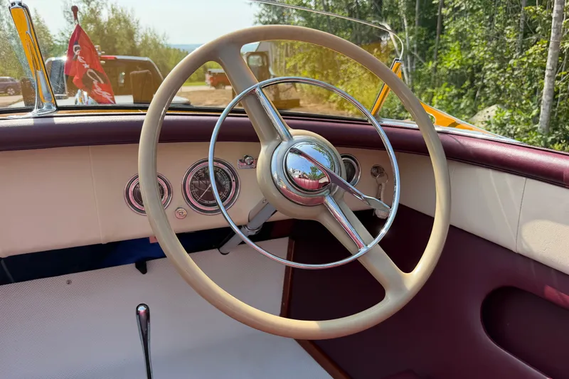 Slide: The Image of 1953 Chris Craft Riviera steering wheel and dashboard with classic gauges and vintage design. - 24