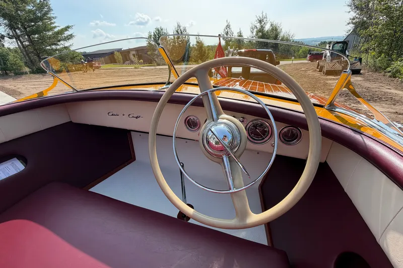 Slide: The Image of Interior view of a 1953 Chris Craft Riviera boat, showcasing vintage steering wheel and dashboard. - 25