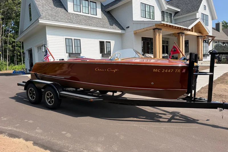 Slide: The Image of 1953 Chris Craft Riviera boat on trailer in front of modern white house. - 7