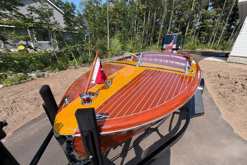 Slide: The Image of 1953 Chris Craft Riviera boat with polished wood finish on a trailer. - 10