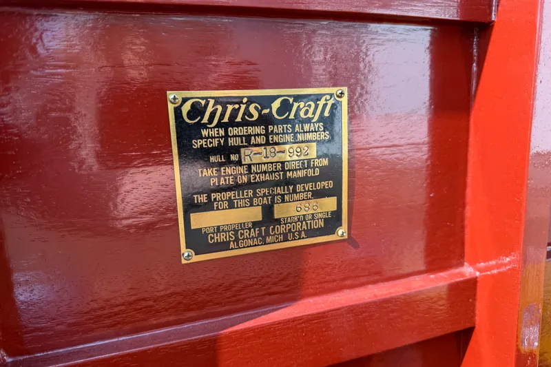 Slide: The Image of 1953 Chris Craft Riviera nameplate on polished wooden surface, displaying hull and engine details. - 23