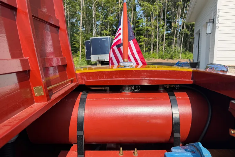 Slide: The Image of 1953 Chris Craft Riviera boat with American flag, showcasing red interior and fuel tank. - 21