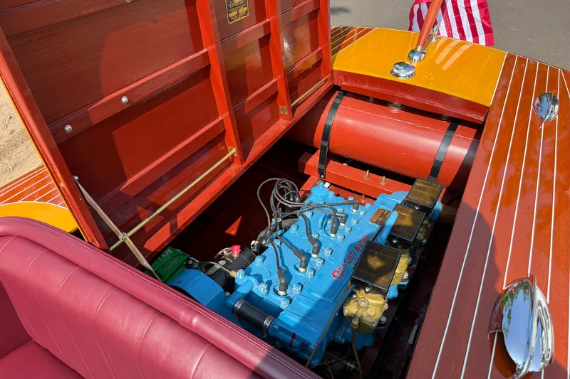 Slide: The Image of 1953 Chris Craft Riviera engine compartment with vibrant blue engine and polished wood finish. - 18