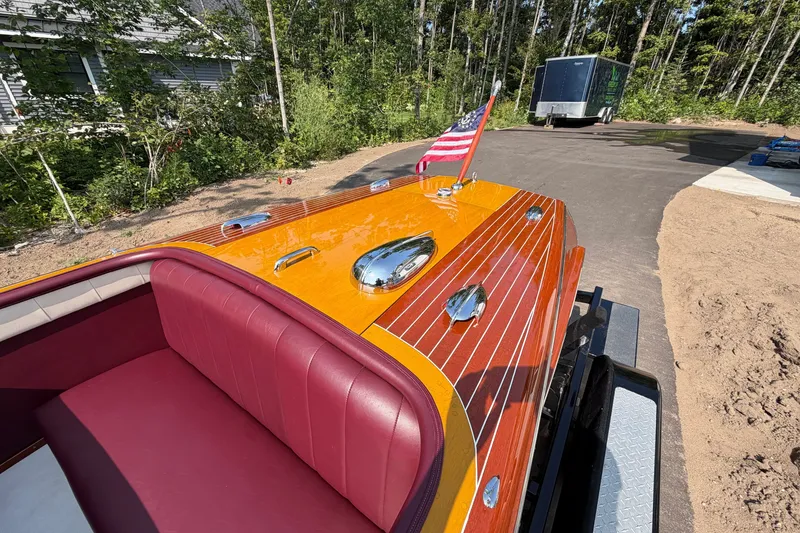 Slide: The Image of 1953 Chris Craft Riviera boat with polished wood finish and American flag. - 17