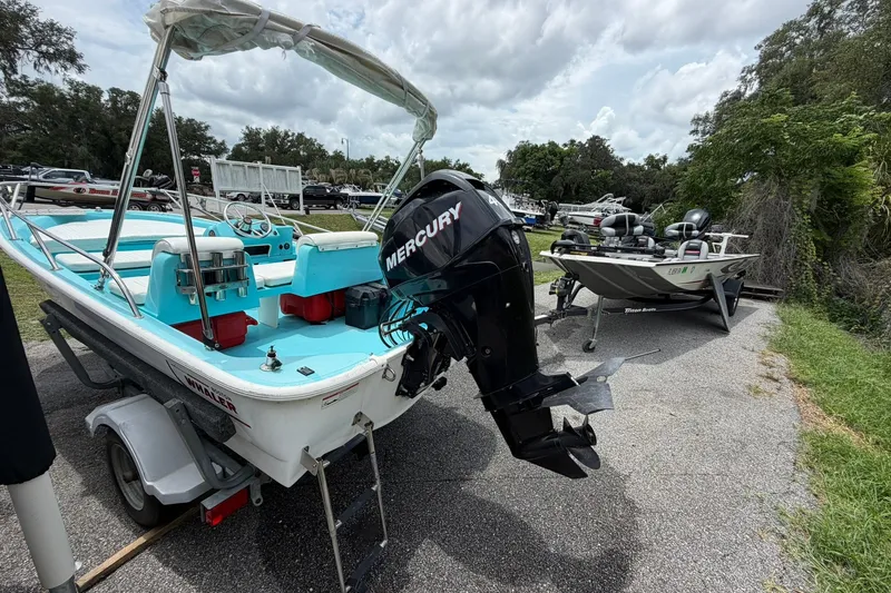 Slide: The Image of 2009 Boston Whaler 130 Sport boat with Mercury engine on trailer, parked outdoors. - 25