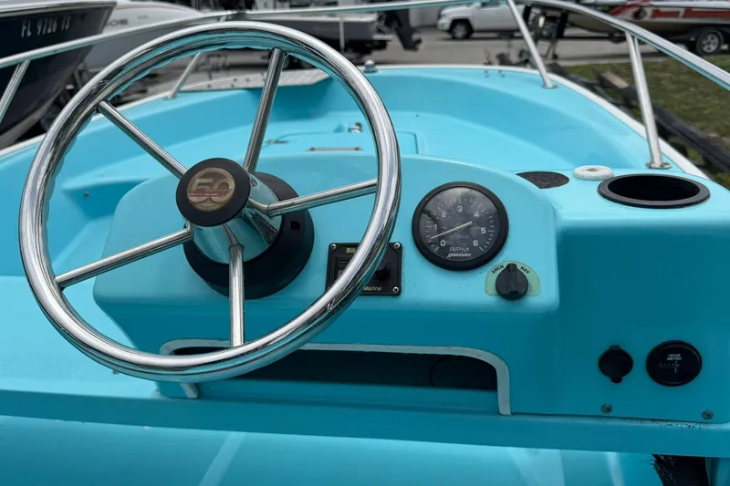 Slide: The Image of 2009 Boston Whaler 130 Sport boat dashboard with steering wheel and gauges. - 16