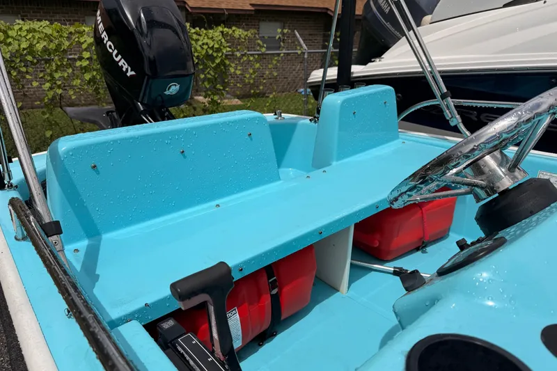 Slide: The Image of 2009 Boston Whaler 130 Sport boat interior with blue seats and Mercury engine. - 13