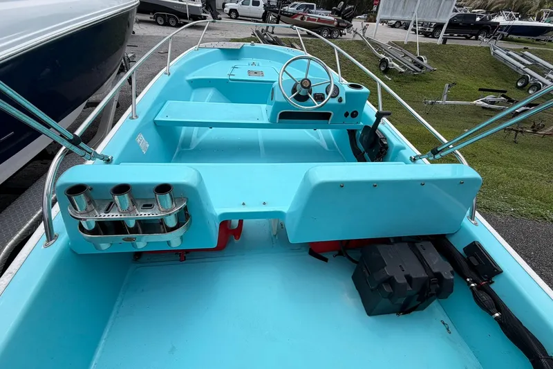 Slide: The Image of 2009 Boston Whaler 130 Sport boat interior with steering wheel and rod holders. - 18