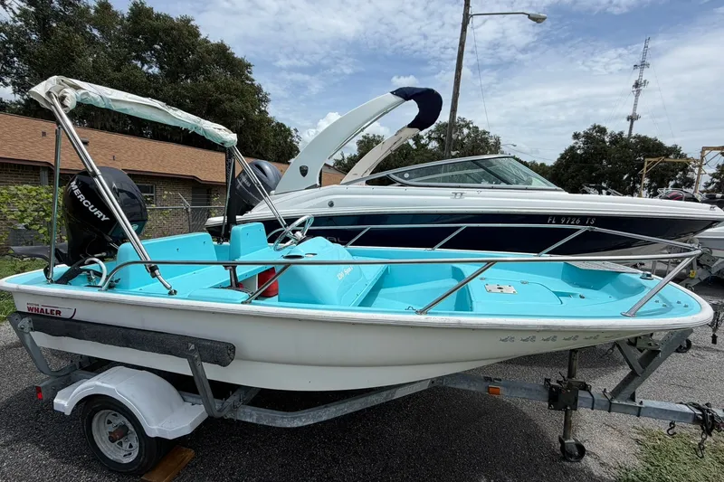 Slide: The Image of 2009 Boston Whaler 130 Sport boat on trailer, featuring a Mercury engine. - 24