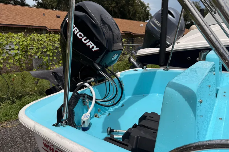 Slide: The Image of 2009 Boston Whaler 130 Sport with Mercury outboard motor, parked outdoors. - 23