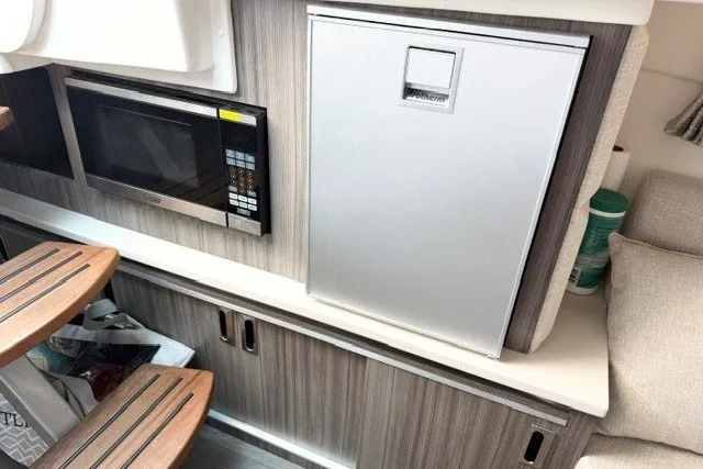 Slide: The Image of 2022 Sea Ray Sundancer 320 interior with microwave and compact refrigerator. - 24