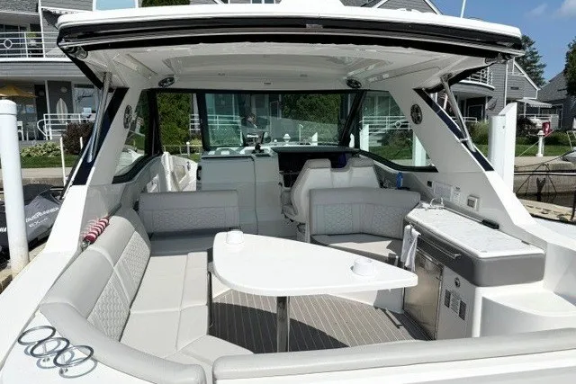 Slide: The Image of 2022 Sea Ray Sundancer 320 boat interior with seating and table, docked at marina. - 7