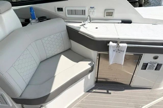 Slide: The Image of 2022 Sea Ray Sundancer 320 interior with white seating and kitchenette area. - 10
