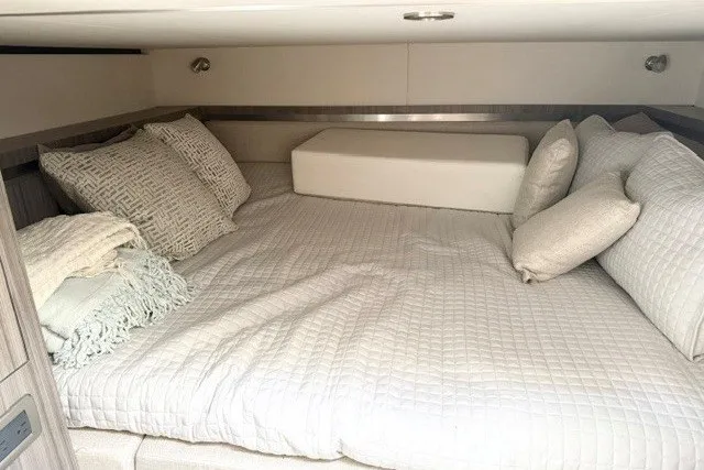 Slide: The Image of Cozy cabin interior of 2022 Sea Ray Sundancer 320 with plush bedding and pillows. - 23