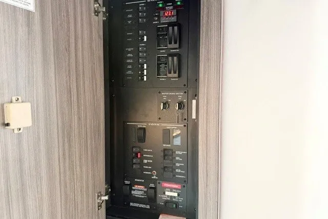Slide: The Image of Electrical panel inside 2022 Sea Ray Sundancer 320 yacht, showcasing circuit breakers and controls. - 27