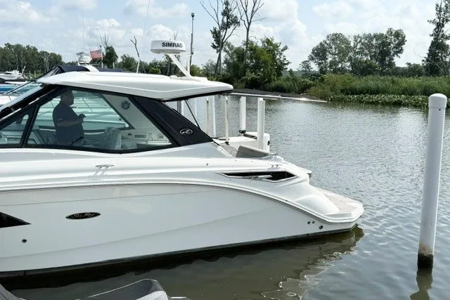 Slide: The Image of 2022 Sea Ray Sundancer 320 yacht docked in a serene marina setting. - 2