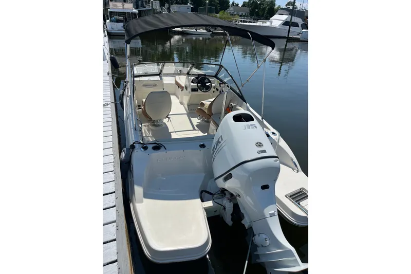 Slide: The Image of 2023 Stingray 191 DC boat with Suzuki outboard motor docked at marina. - 13