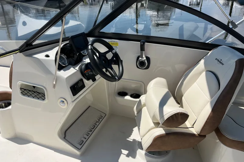 Slide: The Image of 2023 Stingray 191 DC boat interior with steering wheel and comfortable seating. - 17