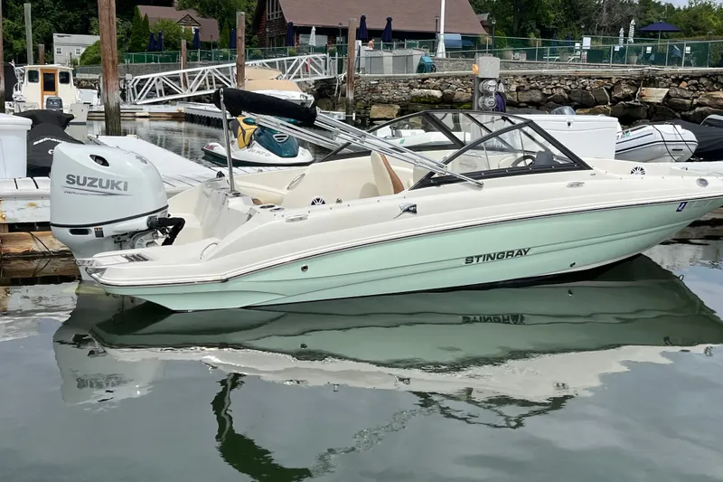 Slide: The Image of 2023 Stingray 191 DC boat docked with Suzuki outboard motor in a marina. - 12