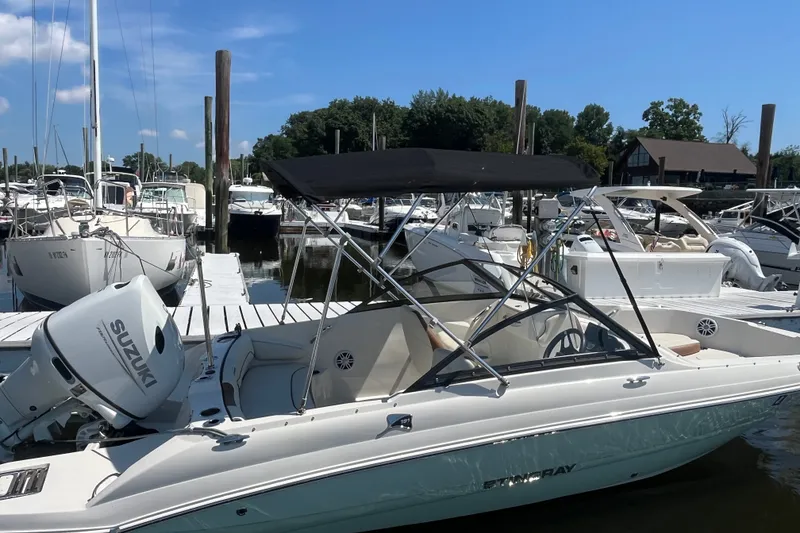 Slide: The Image of 2023 Stingray 191 DC boat docked at marina with Suzuki outboard motor. - 3