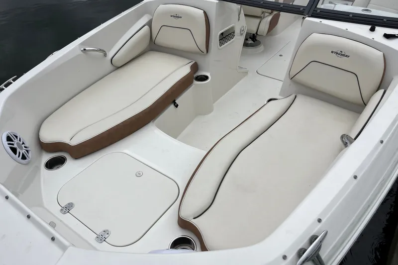 Slide: The Image of 2023 Stingray 191 DC boat interior with white and brown cushioned seating. - 19
