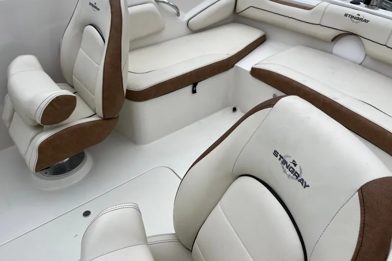 Slide: The Image of 2023 Stingray 191 DC boat interior with white and brown cushioned seating. - 18