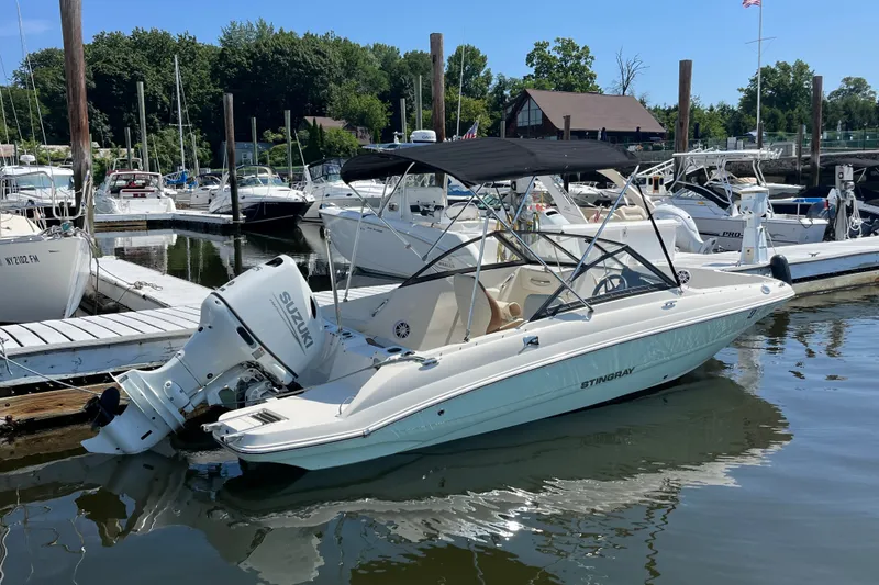 Slide: The Image of 2023 Stingray 191 DC boat docked at marina with Suzuki outboard motor. - 4