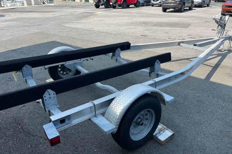 Slide: The Image of Boat trailer for 2023 Stingray 191 DC, parked on asphalt, with visible wheel and hitch. - 23