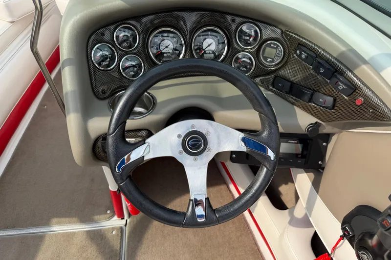 Slide: The Image of Steering wheel and dashboard of 2011 Crownline 21 SS boat, featuring gauges and controls. - 10